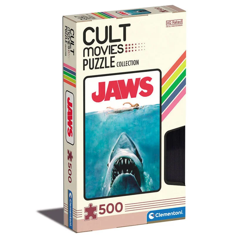 "Puzzle Jaws – 500 pièces – Clementoni. Affiche culte avec le requin surgissant sous la nageuse. Présenté dans une boîte au format VHS rétro. Un incontournable du cinéma d’horreur