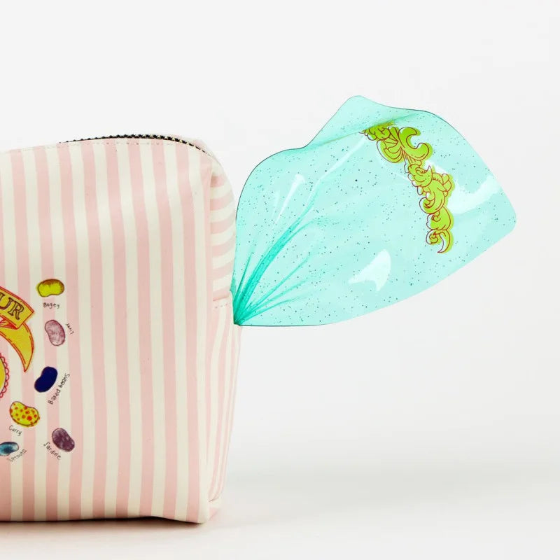 Trousse de voyage Harry Potter – Honeydukes – Bertie Bott’s – 20 x 11,3 x 7 cm. Trousse pastel façon bonbon avec dragées surprises et finitions translucides.