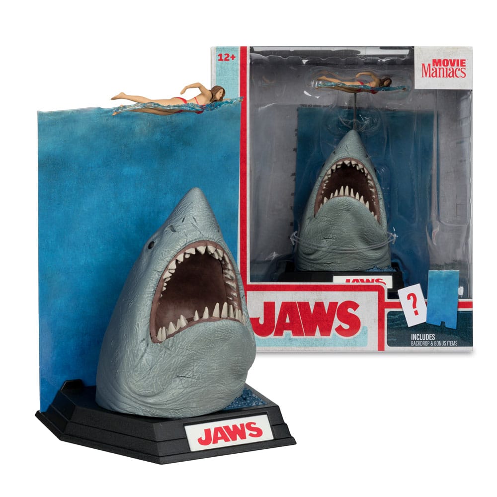 Figurine JAWS – Les Dents de la Mer – 50ème Anniversaire – Movie Maniacs 16 cm. Représentation du requin attaquant une nageuse, avec socle et décor collector. Une pièce incontournable pour les fans de cinéma culte.