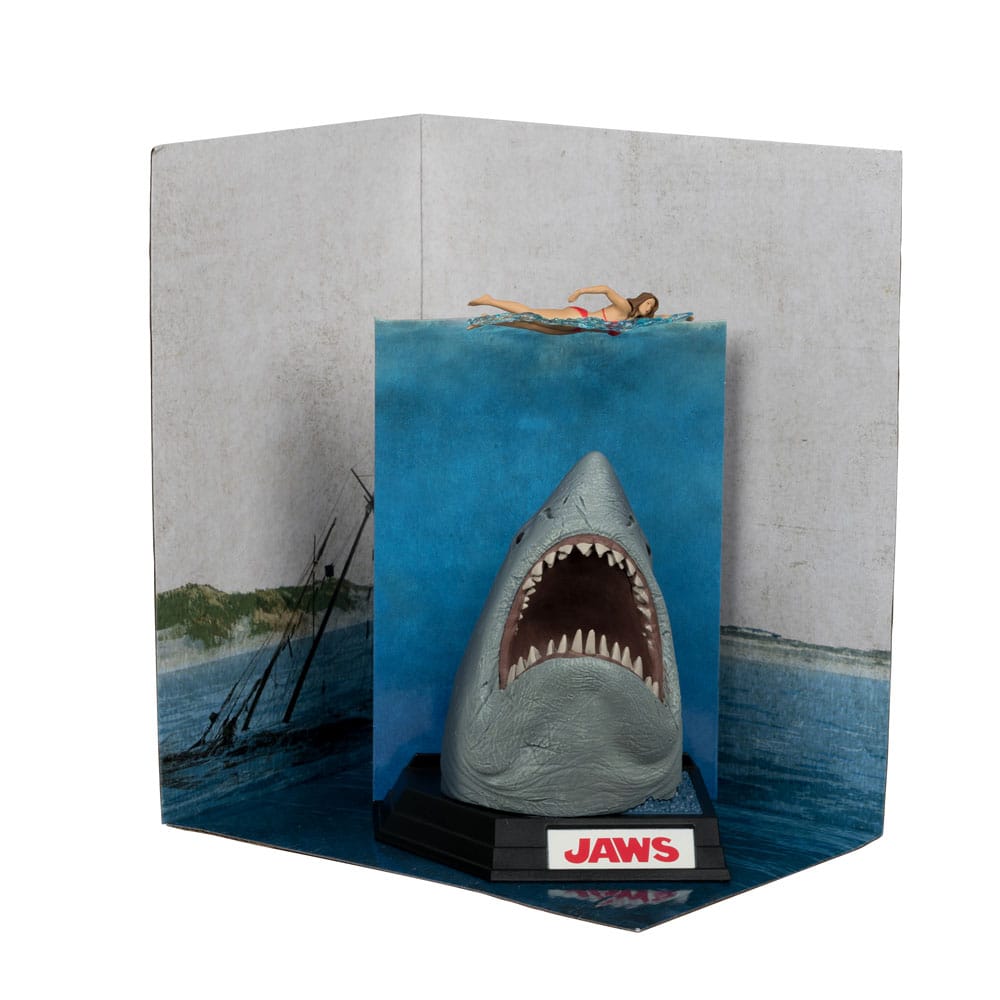 Figurine JAWS – Les Dents de la Mer – 50ème Anniversaire – Movie Maniacs 16 cm. Représentation du requin attaquant une nageuse, avec socle et décor collector. Une pièce incontournable pour les fans de cinéma culte.