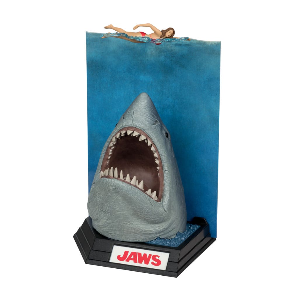 Figurine JAWS – Les Dents de la Mer – 50ème Anniversaire – Movie Maniacs 16 cm. Représentation du requin attaquant une nageuse, avec socle et décor collector. Une pièce incontournable pour les fans de cinéma culte.