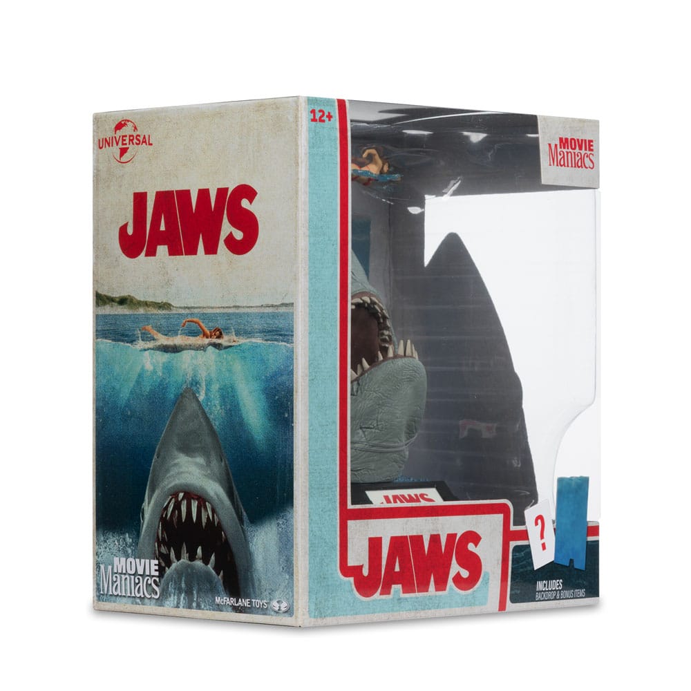 Figurine JAWS – Les Dents de la Mer – 50ème Anniversaire – Movie Maniacs 16 cm. Représentation du requin attaquant une nageuse, avec socle et décor collector. Une pièce incontournable pour les fans de cinéma culte.