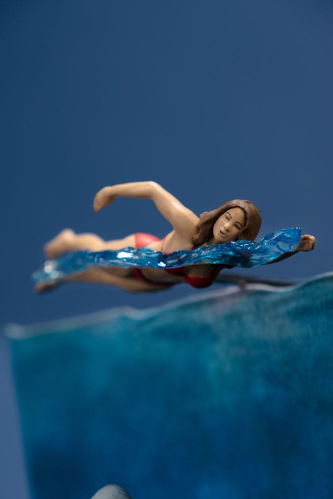 Figurine JAWS – Les Dents de la Mer – 50ème Anniversaire – Movie Maniacs 16 cm. Représentation du requin attaquant une nageuse, avec socle et décor collector. Une pièce incontournable pour les fans de cinéma culte.