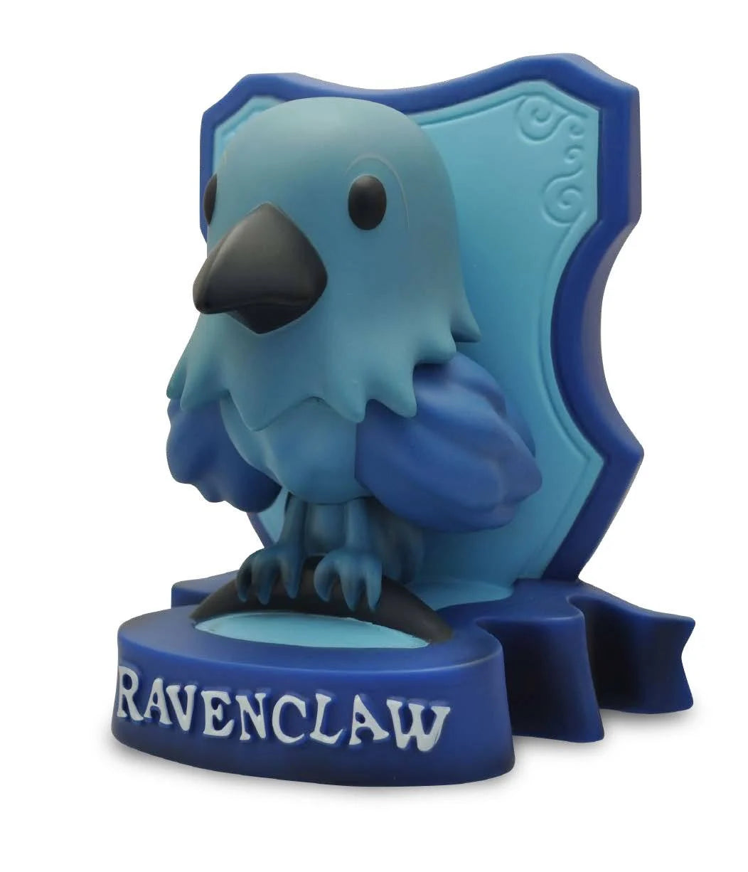 "Tirelire Serdaigle 14 cm – Harry Potter. Modèle en PVC haute qualité peint à la main, représentant l’aigle de la maison Serdaigle sur un blason bleu. Produit sous licence officielle. Un incontournable pour les fans et collectionneurs du Wizarding World."