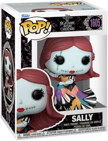 Funko Pop! L’Étrange Noël de Monsieur Jack – Sally (N°1605). Figurine de Sally en robe colorée cousue, cheveux rouges et peau bleue, assise avec élégance, fidèle au style Tim Burton.