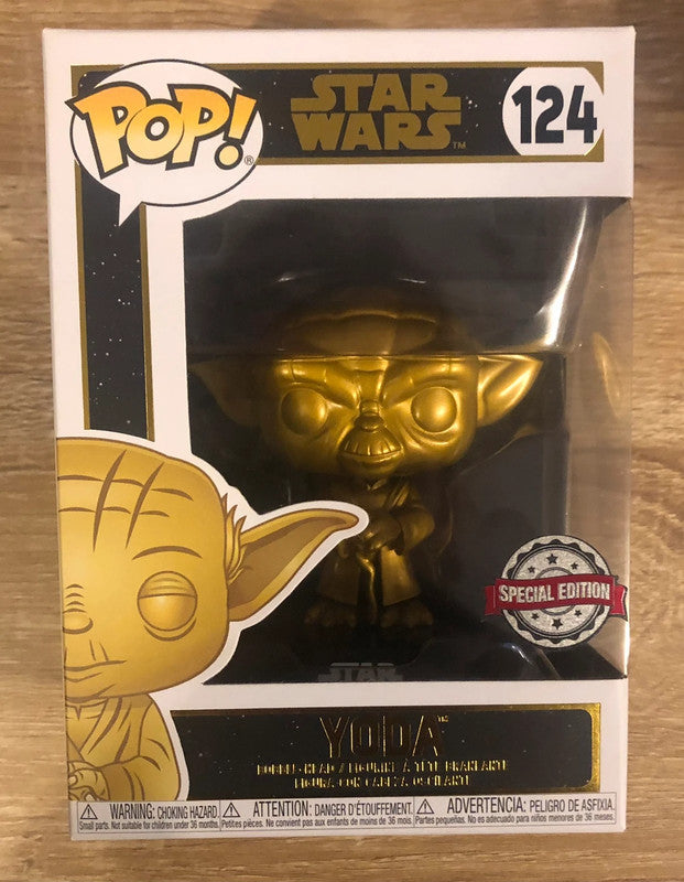 Funko Pop! Yoda 124 - Gold Metallic - Star Wars Special Edition. Figurine dorée du légendaire Maître Jedi Yoda, dans une posture sage et emblématique. Une pièce de collection incontournable pour les fans de Star Wars.