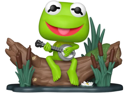 Funko Pop! Deluxe The Muppets – Kermit with Banjo (N°1673). Kermit la grenouille assis sur un tronc, jouant du banjo, dans un décor de marais emblématique.