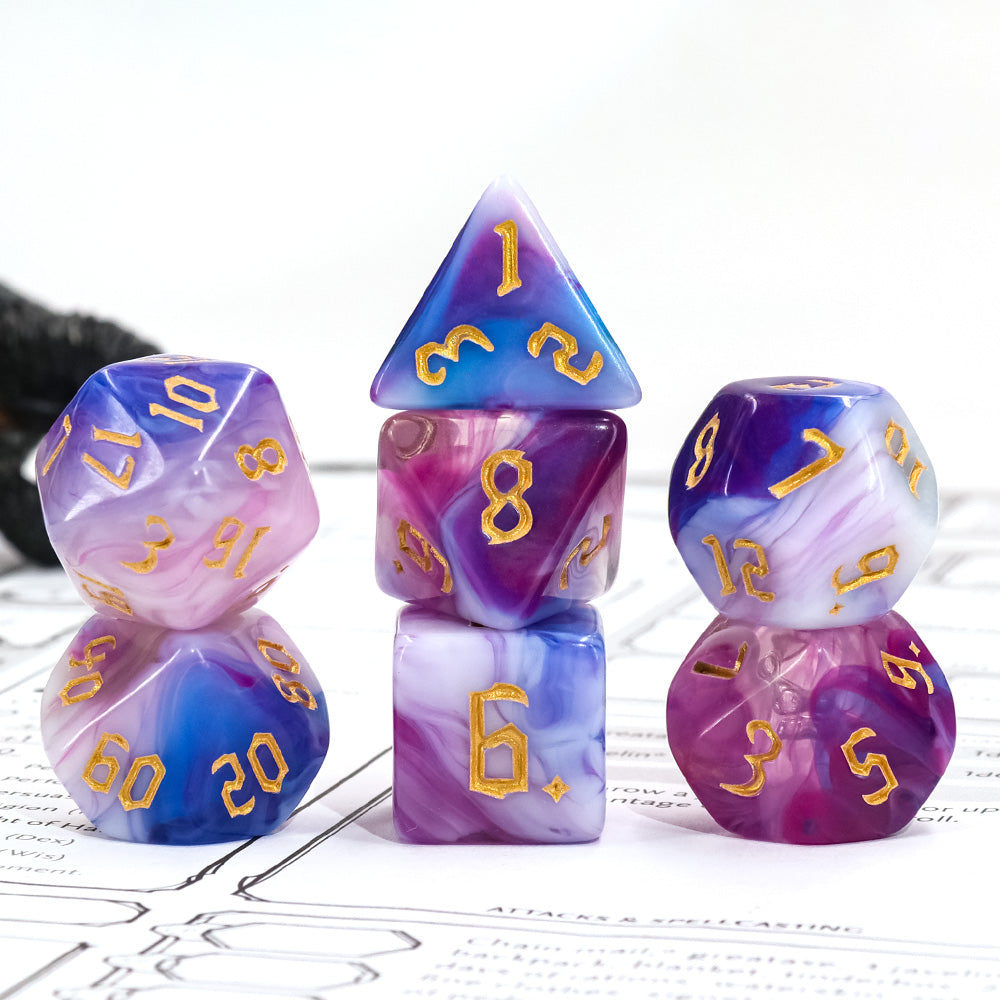 Lot de 7 dés en boîte – Rose Gold – Jeu de rôle. Set complet aux couleurs violettes, roses et bleues marbrées avec chiffres dorés (D4, D6, D8, D10, D00, D12, D20). Un set raffiné et unique pour Donjons & Dragons, Pathfinder et autres jeux de rôle.