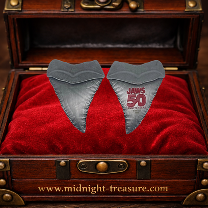 Médaillon officiel Les Dents de la Mer 50ᵉ anniversaire représentant une dent de requin en métal, édition limitée et numérotée, livré avec carte illustrée Amity Island pour collectionneurs et fans de Jaws.