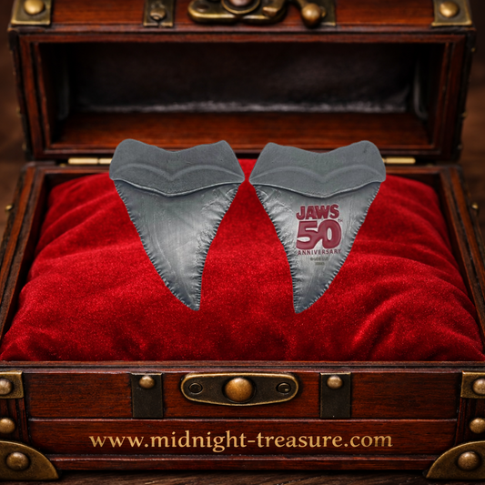 Médaillon officiel Les Dents de la Mer 50ᵉ anniversaire représentant une dent de requin en métal, édition limitée et numérotée, livré avec carte illustrée Amity Island pour collectionneurs et fans de Jaws.
