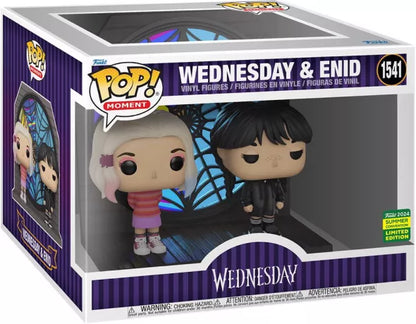 Funko Pop! Moment Wednesday & Enid (N°1541) – SDCC 2024. Figurines de Wednesday Addams et Enid Sinclair devant le vitrail de Nevermore Academy, édition limitée Summer Convention.