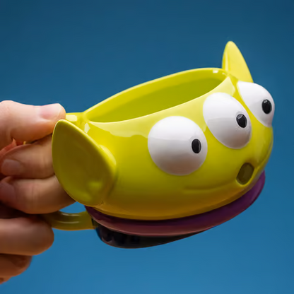 "Mug Disney - Toy Story - Alien (330 ml). Un mug en céramique représentant l’adorable Alien de Pizza Planet. Idéal pour les fans de Toy Story et Pixar. Non compatible lave-vaisselle et micro-ondes.