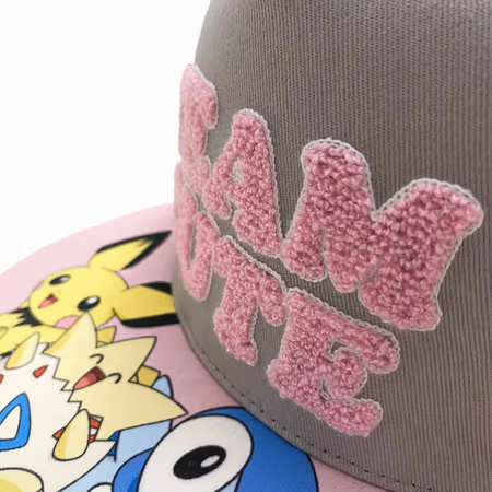 Casquette Pokémon Team Cute - Nintendo. Modèle gris avec broderies épaisses, visière plate et ajustable à l’arrière. Un accessoire incontournable pour les fans de Pokémon.