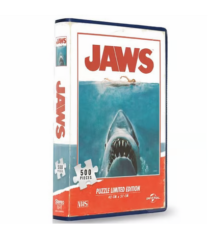 Puzzle Les Dents de la Mer – 500 pièces – Édition Limitée VHS. Un puzzle inspiré de l’affiche culte du film Jaws, livré dans un coffret au format VHS pour une touche vintage. Taille une fois assemblé : 42 x 57 cm. Un must-have pour les fans de cinéma et de puzzles. Produit sous licence officielle.