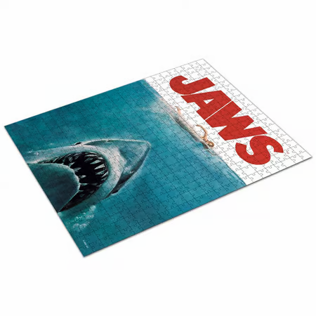 Puzzle Les Dents de la Mer – 500 pièces – Édition Limitée VHS. Un puzzle inspiré de l’affiche culte du film Jaws, livré dans un coffret au format VHS pour une touche vintage. Taille une fois assemblé : 42 x 57 cm. Un must-have pour les fans de cinéma et de puzzles. Produit sous licence officielle.