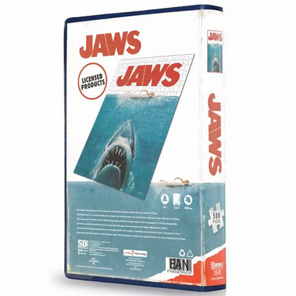 Puzzle Les Dents de la Mer – 500 pièces – Édition Limitée VHS. Un puzzle inspiré de l’affiche culte du film Jaws, livré dans un coffret au format VHS pour une touche vintage. Taille une fois assemblé : 42 x 57 cm. Un must-have pour les fans de cinéma et de puzzles. Produit sous licence officielle.