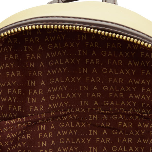 Sac à dos Loungefly – Star Wars – Jakku – 23 x 27 x 11 cm. Sac marron et beige avec design désertique inspiré de la planète Jakku, poche frontale zippée et doublure thématique “In a galaxy far, far away…”.