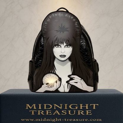 Mini sac à dos Loungefly – Elvira Mistress of the Dark – Cosplay Light-Up – 22,8 x 26,6 x 11,4 cm. Sac noir en simili cuir avec portrait d’Elvira et boule de cristal lumineuse.

