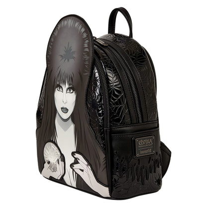 Mini sac à dos Loungefly – Elvira Mistress of the Dark – Cosplay Light-Up – 22,8 x 26,6 x 11,4 cm. Sac noir en simili cuir avec portrait d’Elvira et boule de cristal lumineuse.

