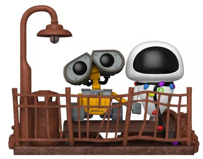 Funko Pop! Disney Pixar – WALL-E & EVE Moment (N°1119). Scène emblématique avec WALL-E et EVE sur une passerelle rouillée sous un lampadaire. Figurine détaillée et poétique, parfaite pour les fans Pixar.